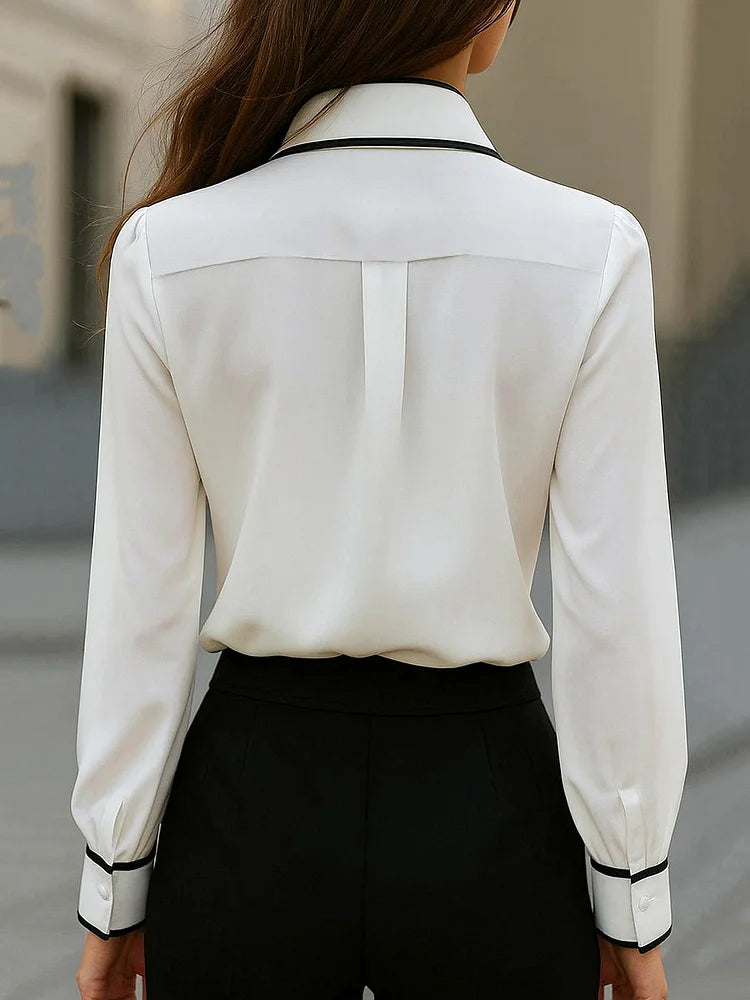 Blusa elegante con cuello anudado y ribete en contraste