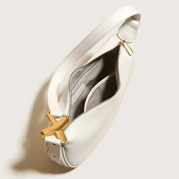 Bolso Livia – Media luna en cuero beige y hebilla dorada escultórica